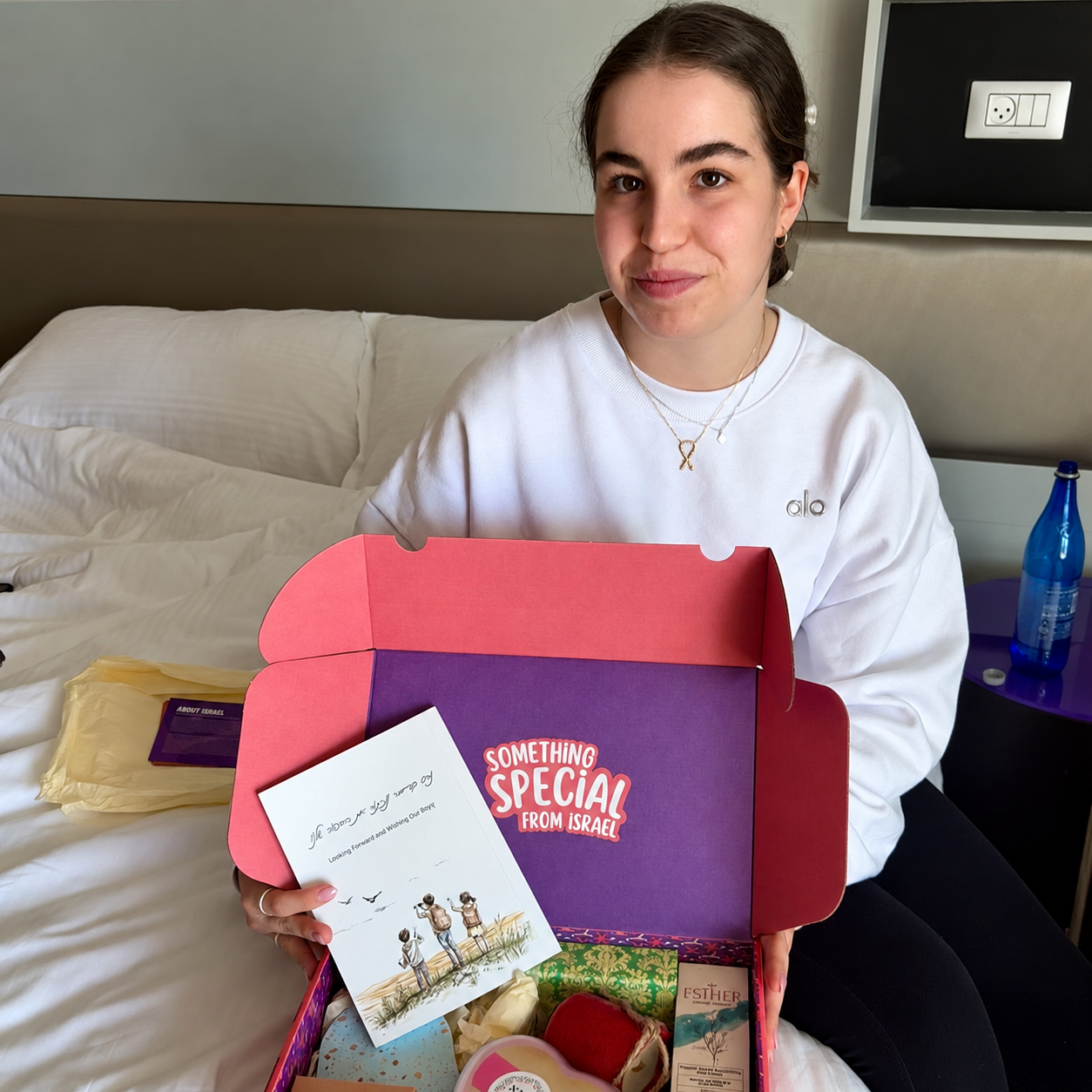 Woman holding an open Purim gift package during the 2025 campaign